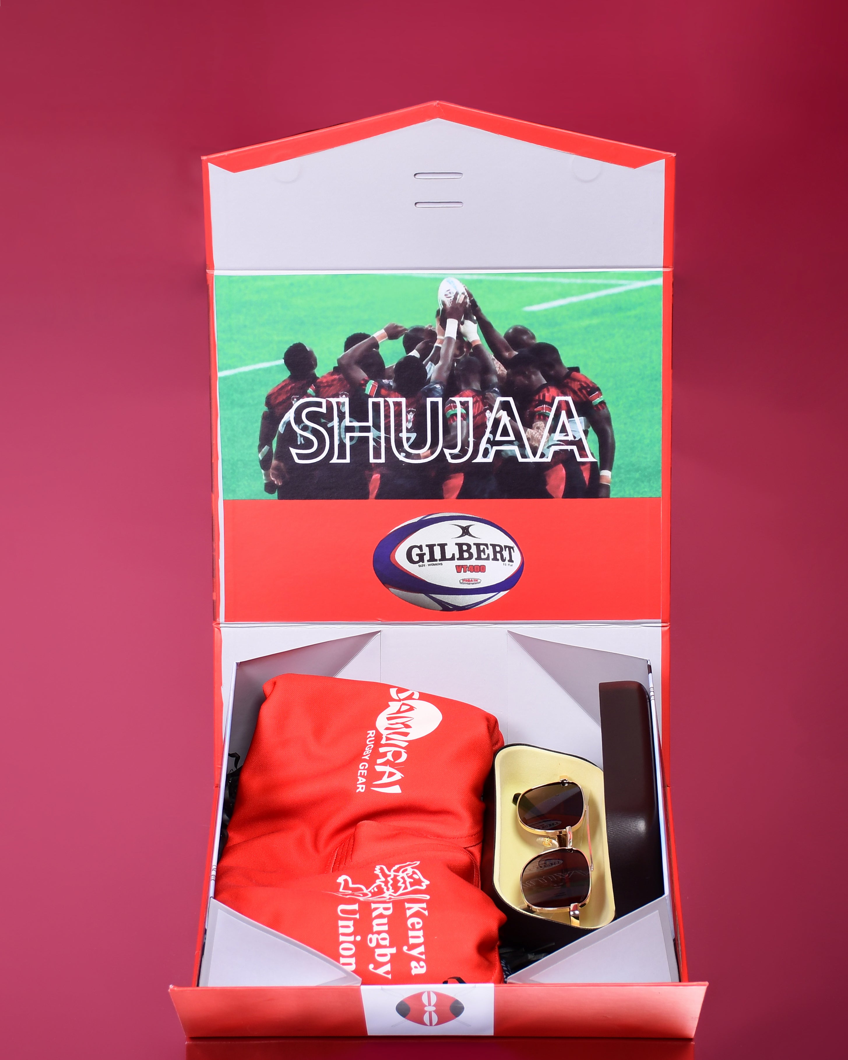 Packaged sports kit with 'SHUJAA' branding on a red background