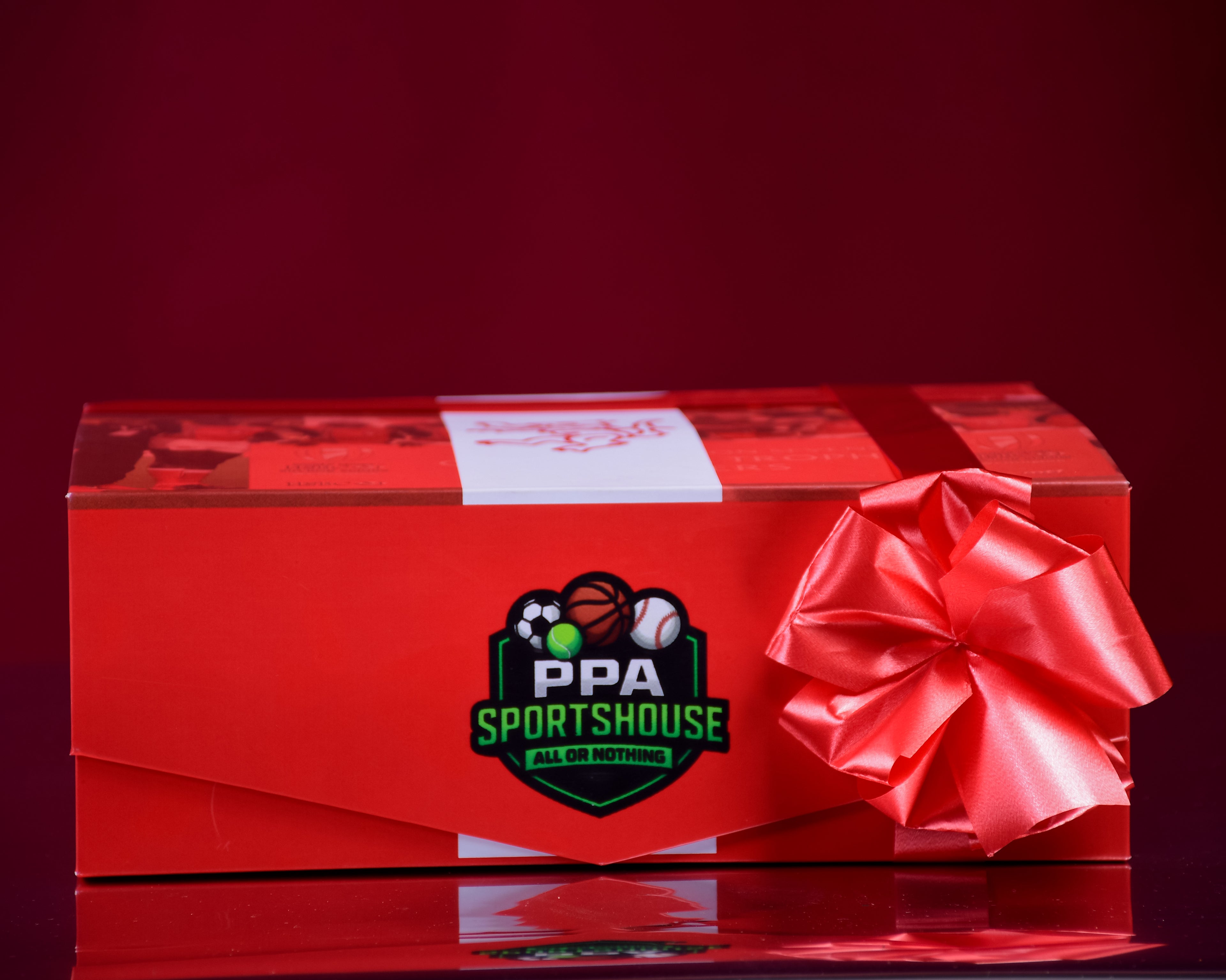 Red gift box with a bow and PPA Sportshouse logo on a red background