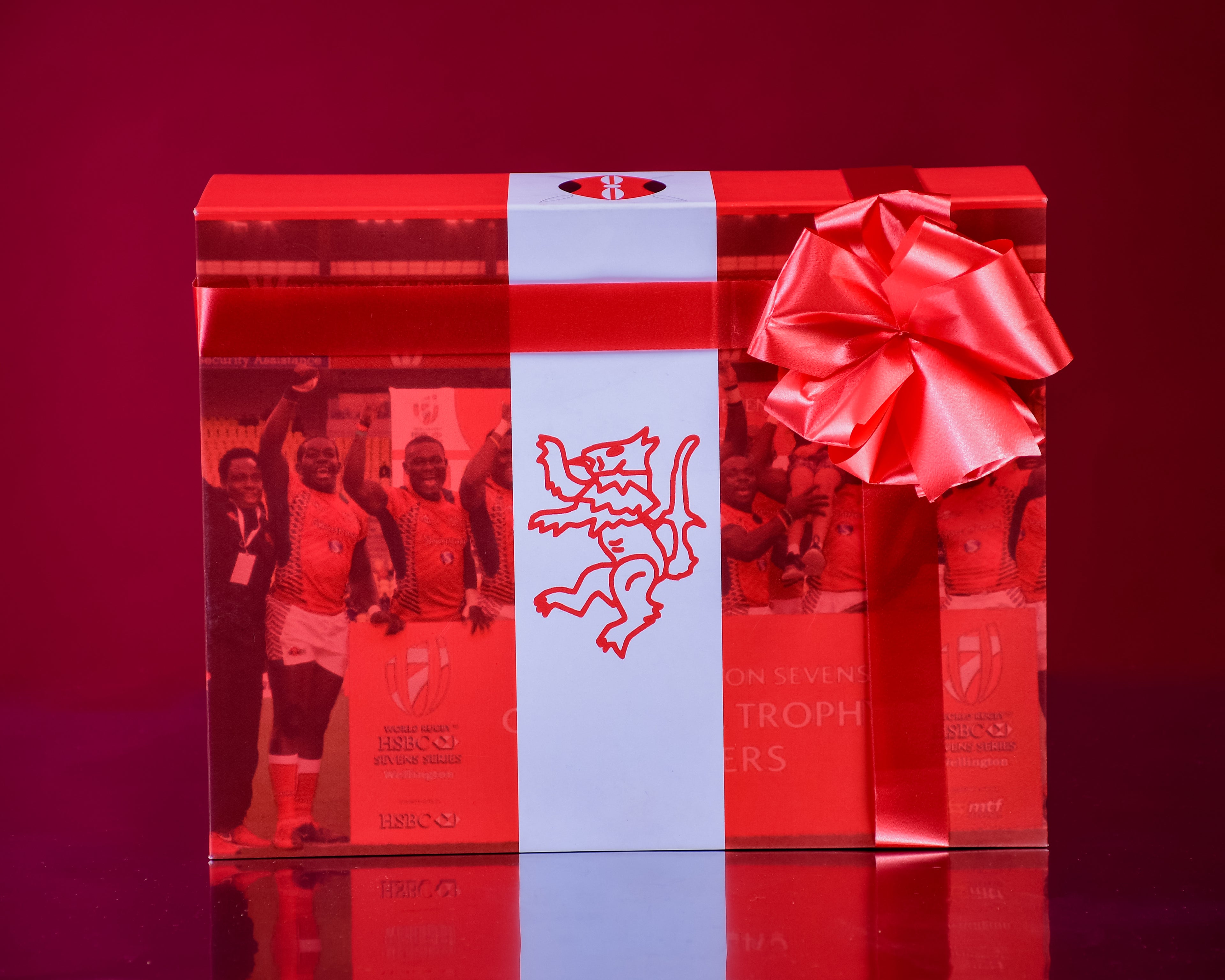 Gift box with a ribbon and a lion emblem on a red background